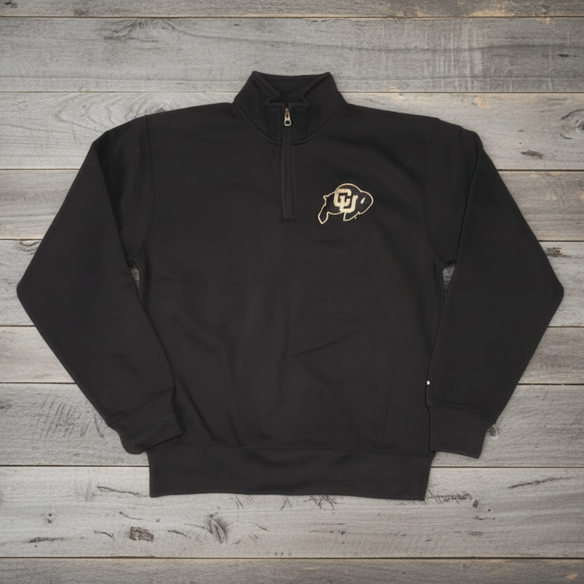 A black quarter zip sweatshirt with the Colorado Buffaloes logo on the chest, laid flat on a wooden surface.